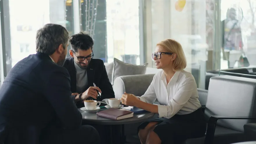 Insurance advisors and clients discussing options together at a table